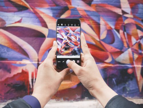 Mobile camera being used to take a photograph of an abstract painting.